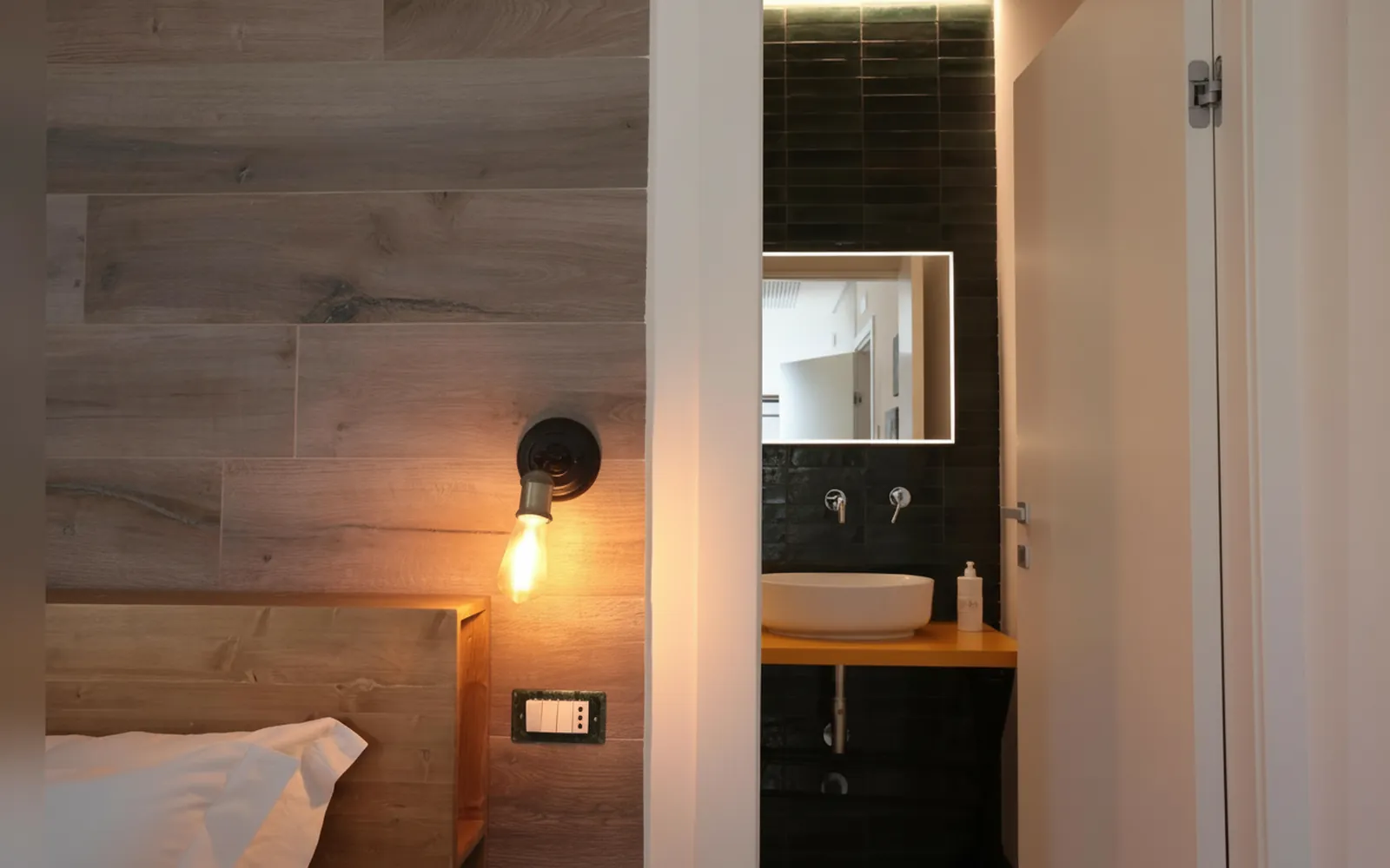 Il bagno privato visto dalla camera, con il lavabo e lo specchio